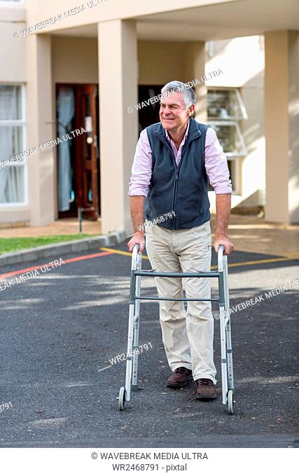 Senior man walking with a walking frame outside the hospital