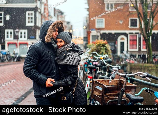 guy and girl in the street in the rain posing on the camera