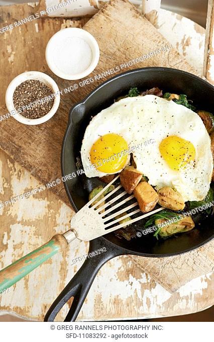 Vegetable Hash Topped with Two Sunny Side Up Eggs in a Skillet