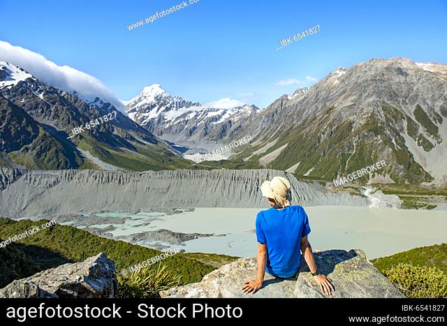 Hiker sitting on a rock, view of Hooker Valley with Mueller Lake, Hooker Lake and Mount Cook, Sealy Tarns Track, Hooker Valley, Mount Cook National Park