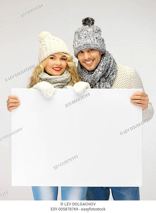 picture of family couple in a winter clothes holding blank board
