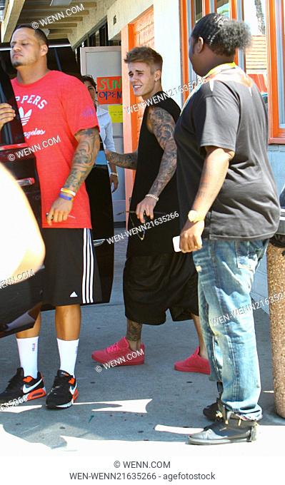 Justin Bieber arrives at Sushi Dan in Studio City in his Ferrari 458 Italia, wearing pink suede Adidas sneakers. He left in a 2014 Cadillac Escalade driven by...