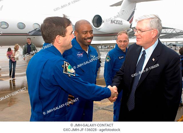 Johnson Space Center's (JSC) director Michael L. Coats (right) greets astronauts Rex Walheim (left) and Leland Melvin, STS-122 mission specialists