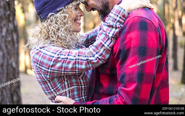 Romantic adult couple hug and love outdoor in the woods - happy people man and woman together lover embracing - young male and female enjoy time and leisure...