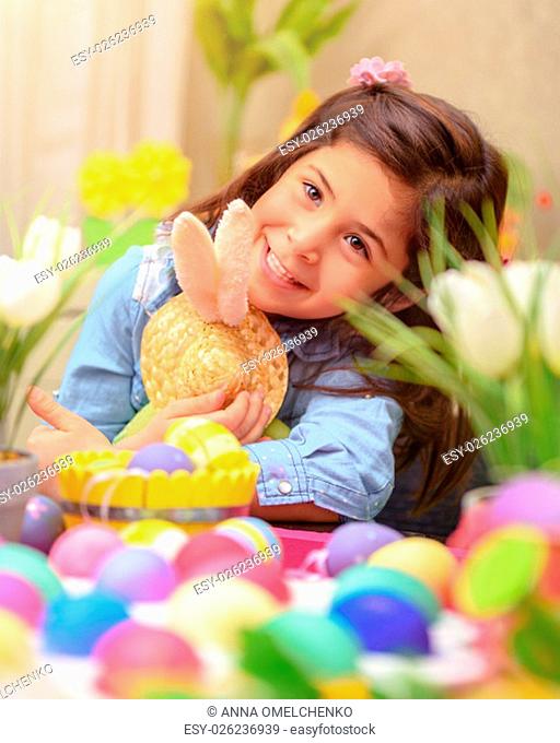 .Portrait of adorable little girl with pleasure hugging her friend, soft toy Easter bunny, having fun at home in happy holiday day