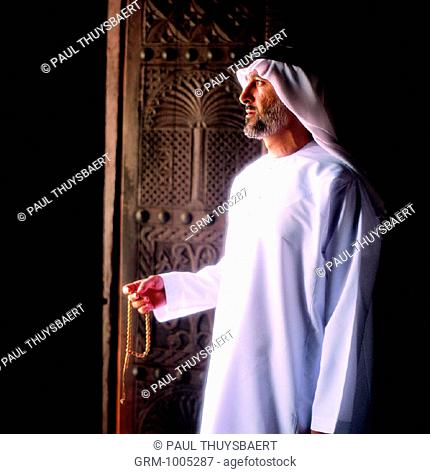 Arab man holding prayer beads in his hands
