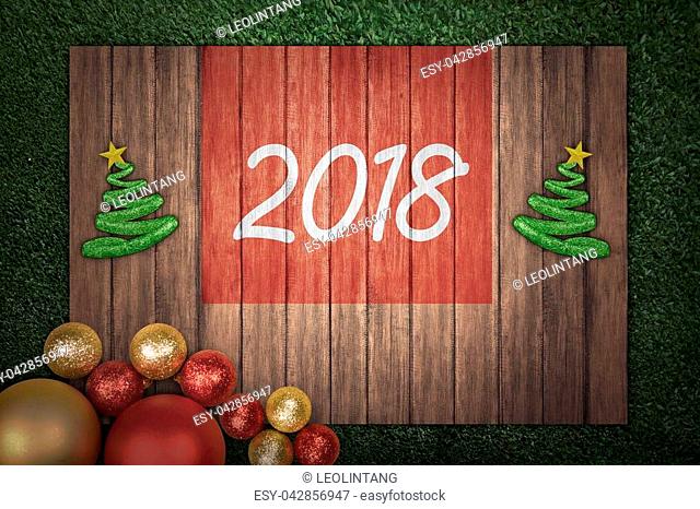 Christmas tree and 2018 number on wooden board on the grass