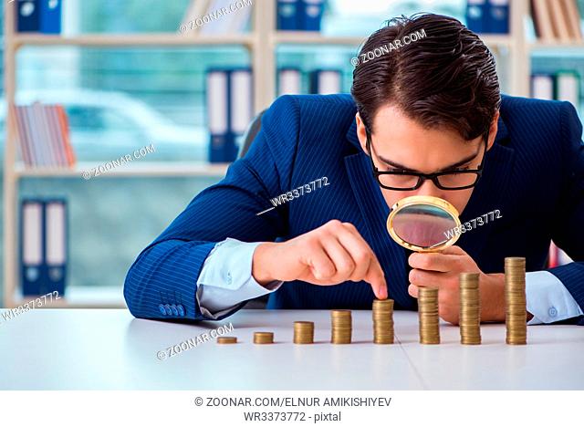 Businessman with stacks of coins in the office