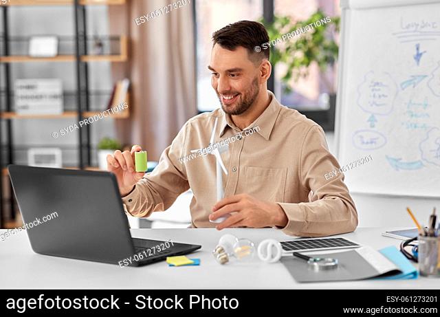 male teacher with laptop and wind turbine at home