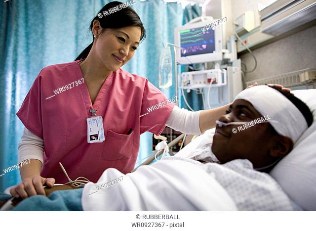 Nurse talking with boy in hospital bed