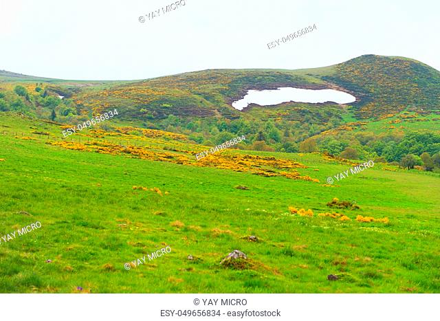 Green landscape with eternal snow in French Auvergne Massif du Sancy Puy de Dome