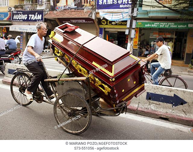 Man transporting a coffin on rickshaw. Hanoi. Vietnam