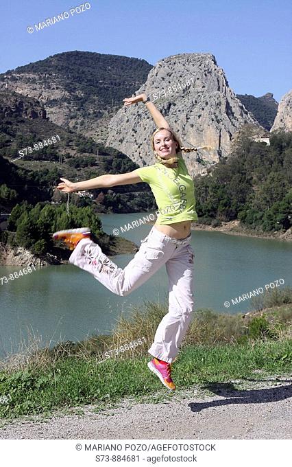 Mujer de 30 años saltando delante del Pantano de El Chorro, rio Gudalhorce, Ardales, Málaga