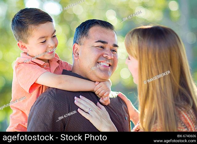 Happy attractive young mixed-race family having fun outdoors