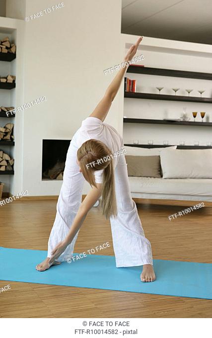 A blonde woman exercising in her hall