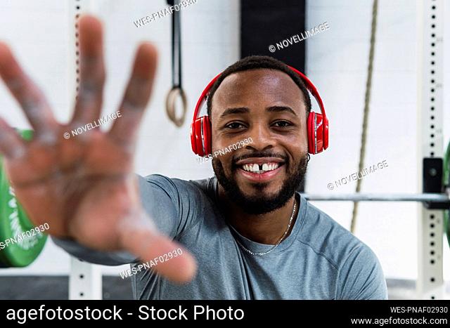 Sportsman with gap teeth gesturing in gym