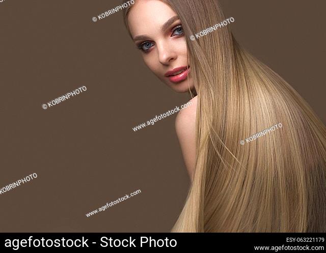 Beautiful blond girl with a perfectly smooth hair, classic make-up. Beauty face. Picture taken in the studio on a white background