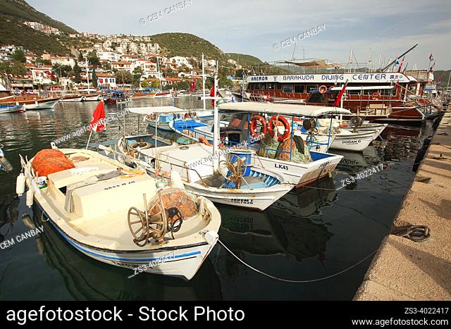 Traditional fishing boats inside the harbor at the town center with the traditional houses at the background, Kas, Antalya Province, Mediterranean Coast