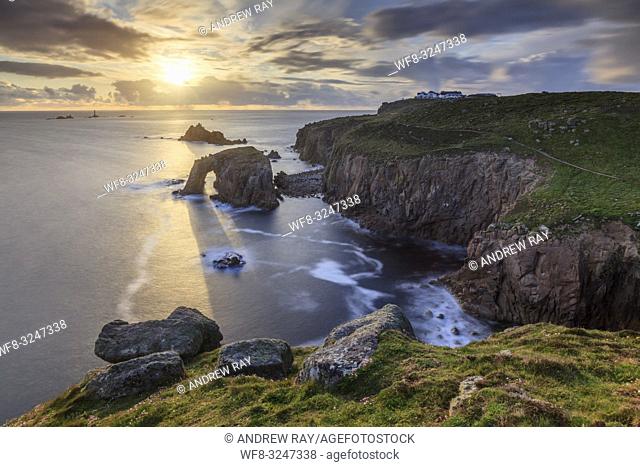 The setting sun at Land's End in Cornwall, captured using a long shutter speed on an evening in mid May when sunlight was shining though the Enys Dodman natural...
