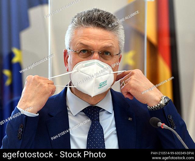 14 May 2021, Brandenburg, Potsdam: Lothar Wieler, President of the Robert Koch Institute, takes off his FFP2 mask before his questioning in the committee of...