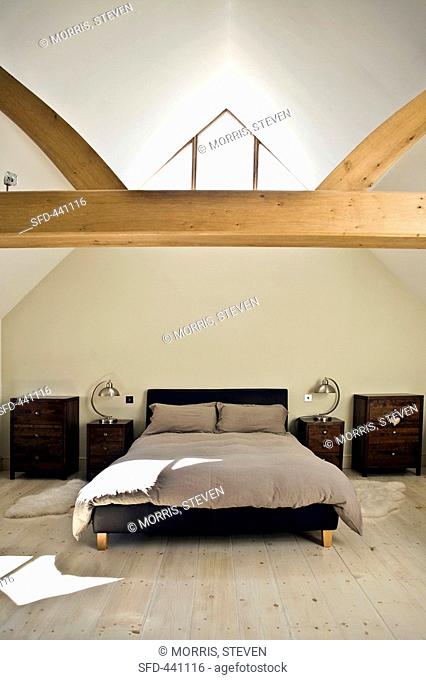 Attic bedroom with wooden beam and wooden floor