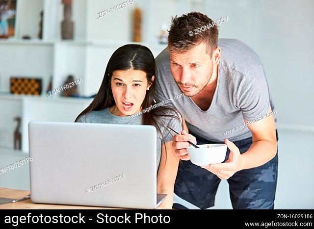 Junges Paar schaut Tutorial zum Haare selber färben oder tönen am Laptop Computer