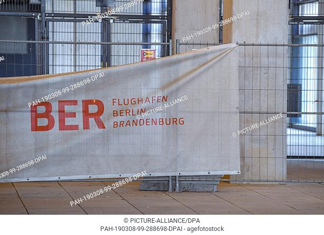 06 March 2019, Brandenburg, Schönefeld: A construction fence stands in front of the terminal of the capital airport Berlin Brandenburg Willy Brandt (BER)