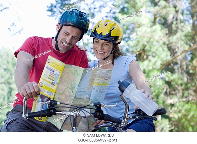 Couple on bicycles looking at map