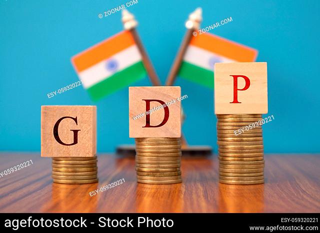 GDP or gross domestic product in wooden block letters on Coins in Increasing order with Indian flag as a background