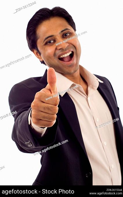 Happy young Indian businessman showing thumbs up sign isolated over white background
