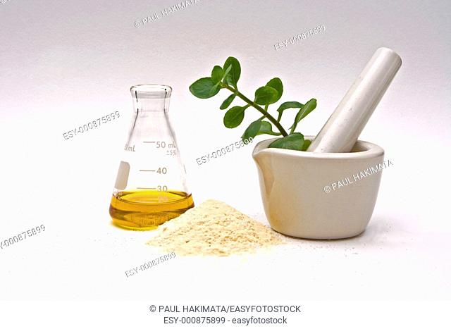 A yellow liquid in a flask with a powder in front and a white mortar with asome leaves in it on a white background