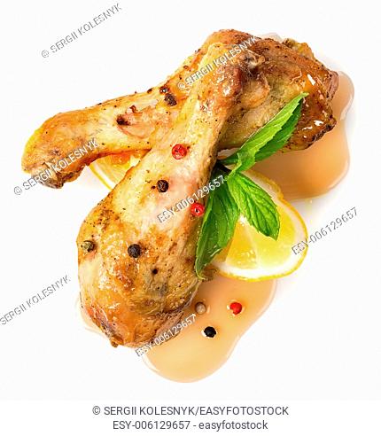 Fried chicken legs with sauce, lemon and greens