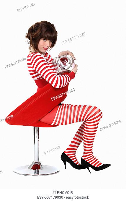 A cute brunette wearing red and white stripes and eating marshmallows