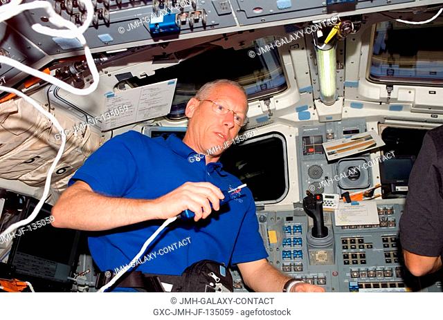 Astronaut Patrick Forrester, STS-117 mission specialist, uses a communication system on the aft flight deck of Space Shuttle Atlantis