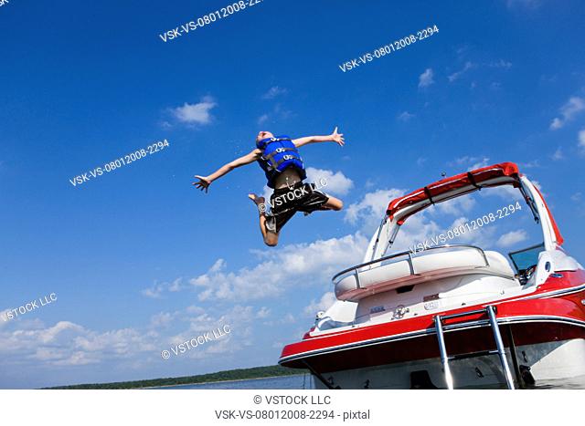 USA, Missouri, Stockton, Stockton Lake, boy 6-7 jumping off boat