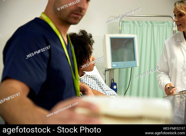 Doctor discussing with patient in medical room at hospital
