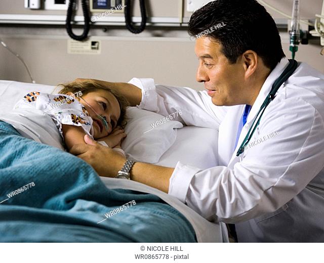 Male doctor with young girl in hospital