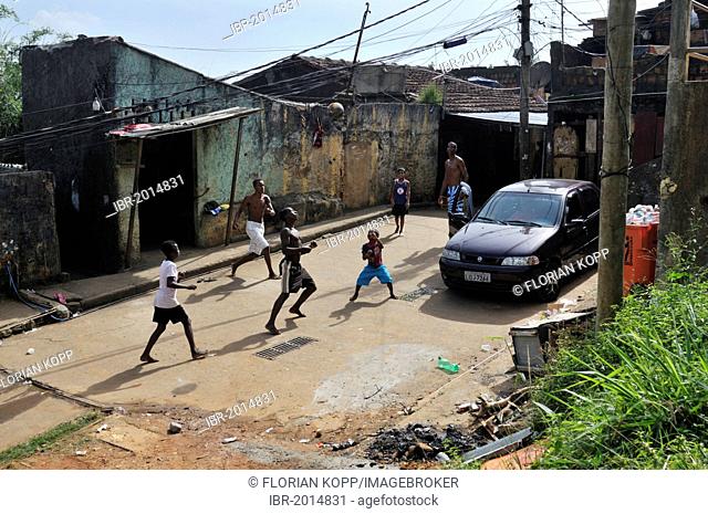 Youths playing football in the street, slum district of Favela Morro da Formiga, Tijuca district, Rio de Janeiro, Brazil, South America