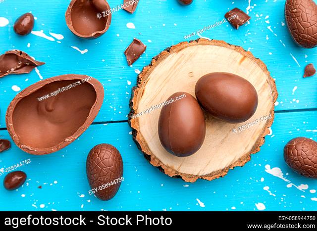 Delicious chocolate Easter bunny, eggs and sweets on rustic background