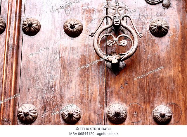Old and ornate wooden door with doorknocker in Toledo
