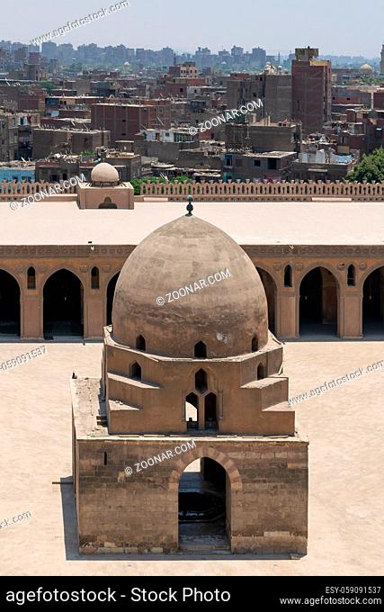 Aerial view of ablution fountain at the courtyard of Ibn Tulun public historical mosque with grunge houses in the background, Old Cairo, Egypt