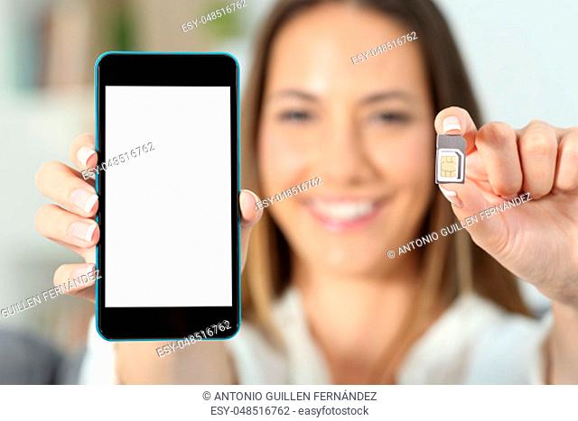 Close up of a happy woman hand showing a sim card and a smart phone