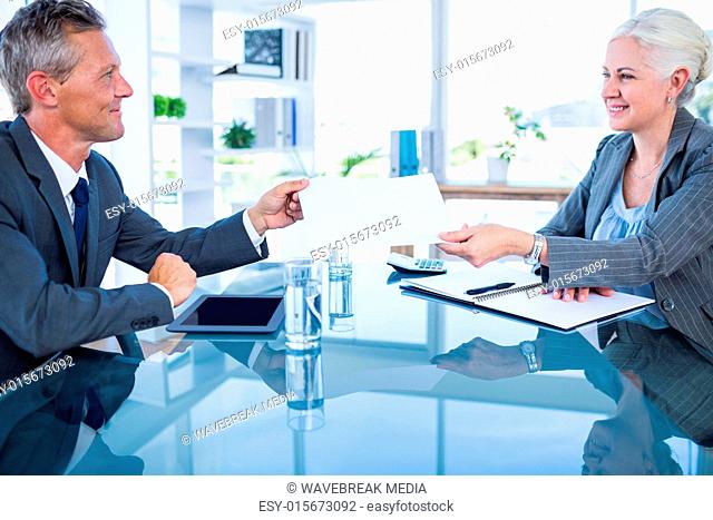 Businessman giving paper to hos colleague