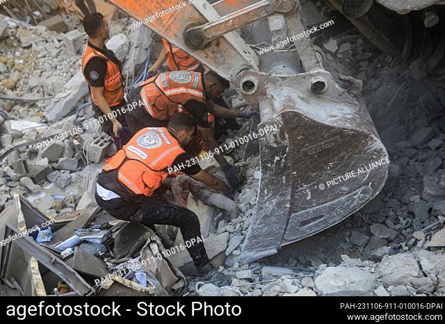 06 November 2023, Palestinian Territories, Khan Yunis: A Palestinian civil defense crew recovers the body of a dead child