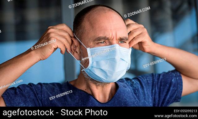 Man wearing facial disposable mask to avoid viral infection. Virus protection