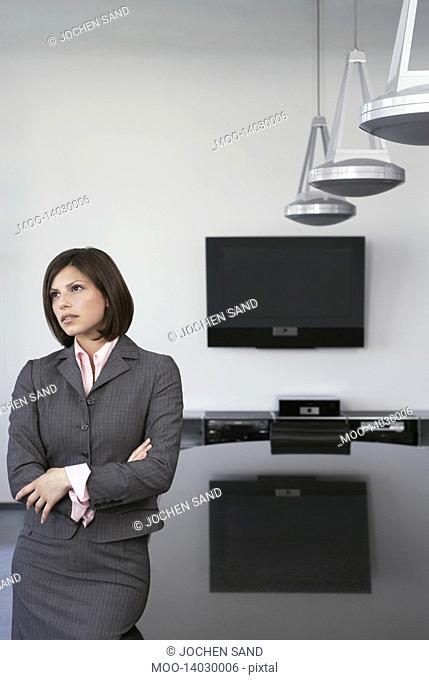Business woman leaning against table in conference room