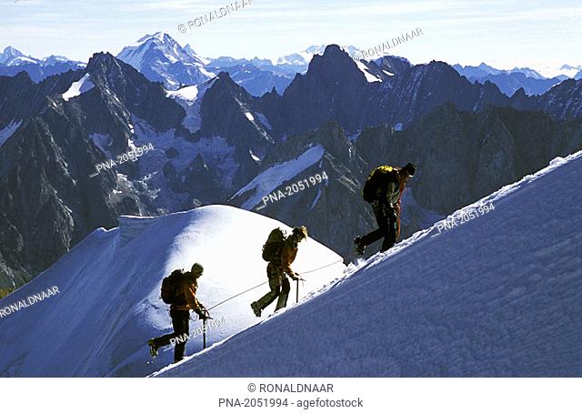 Team climbing to the top of the Aiguille du Midi, Alps, France  In the background: Dent Blanche, Gran Combin, Matterhorn