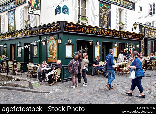 Paris, France - May 12, 2017: The streets of Montmartre district with people sitting in cafes and restaurant