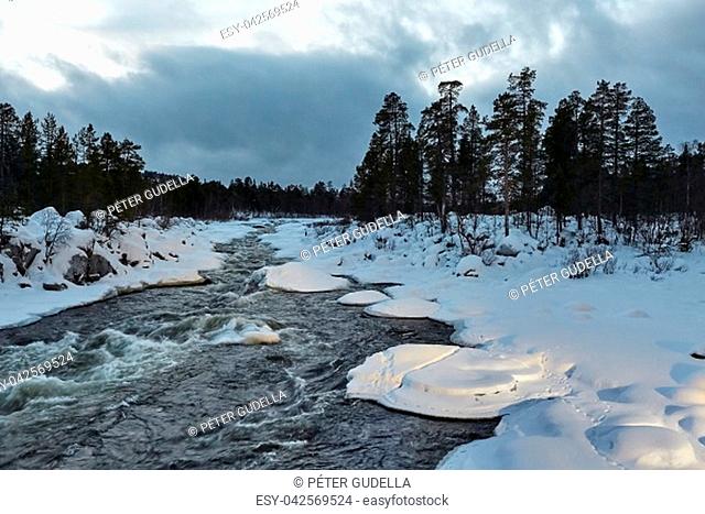 Fast river flowing in the nordic winter