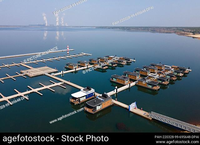 25 March 2022, Saxony, Boxberg: Houseboats lie in the water in Klitten harbor on Lake Bärwalde in front of the Boxberg power plant